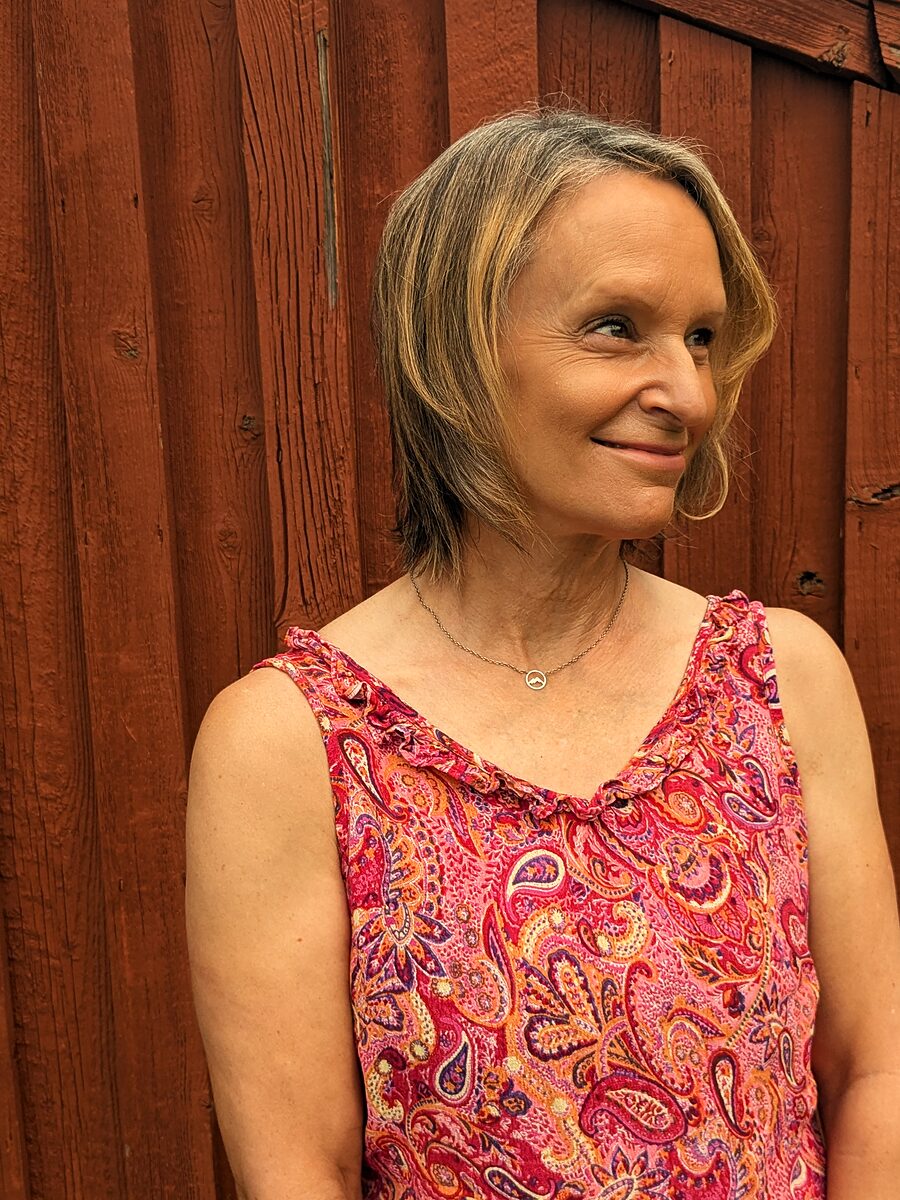 Anne Marie Norling by the barn, turned away from the camera